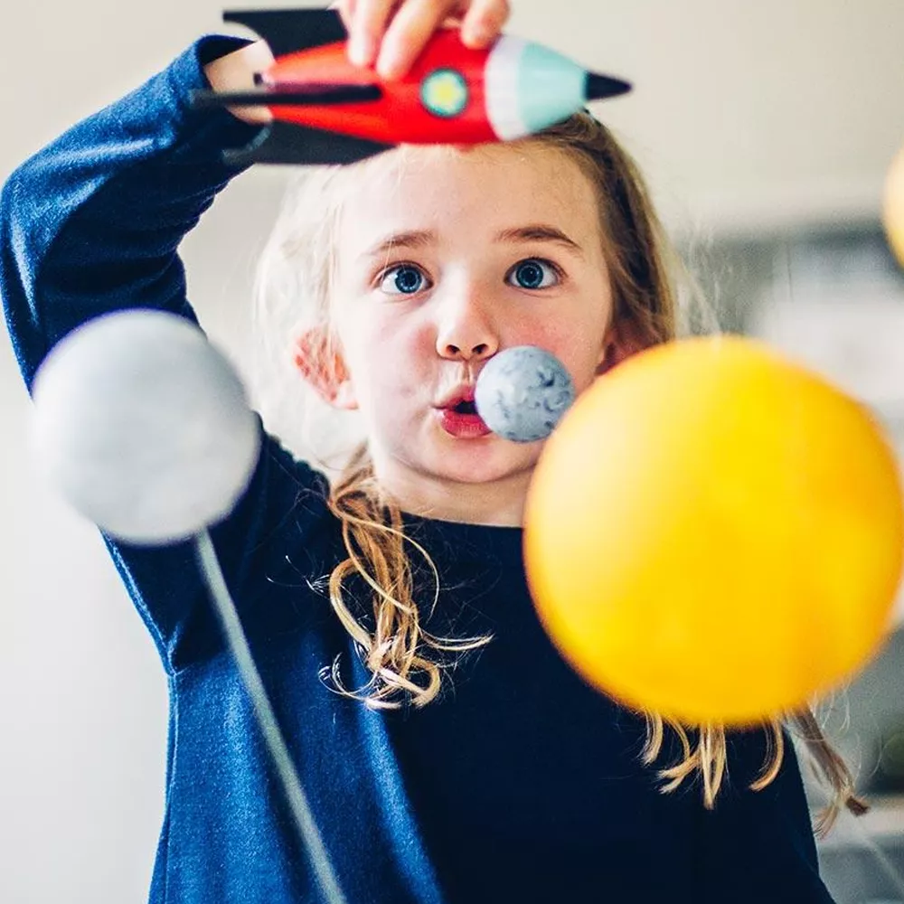 Young girl playing with a rocket ship.