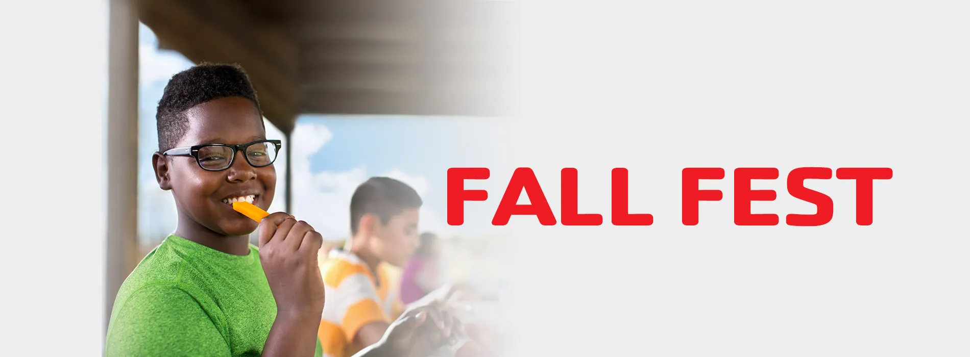 Boy eating a snack. Red text displaying "Fall Fest"