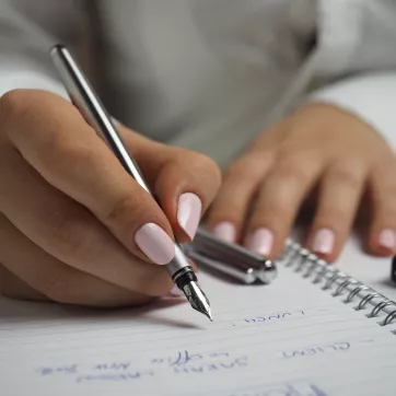 Woman writing down goals for herself.